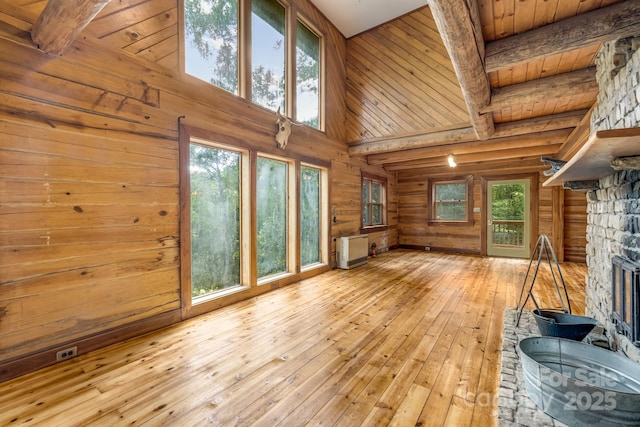 465 Youngs Gap Rd, Fletcher, NC 28732 - unfurnished living room with hardwood / wood-style flooring, log walls, plenty of natural light, a towering ceiling, and a stone fireplace