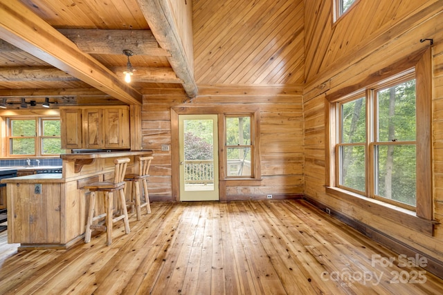 465 Youngs Gap Rd, Fletcher, NC 28732 - kitchen featuring light wood-style floors, a wooden ceiling with exposed beams, brown cabinets, wood walls, and a kitchen bar