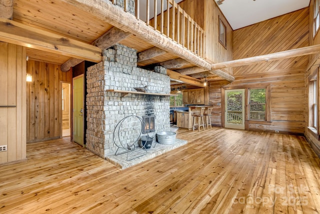 465 Youngs Gap Rd, Fletcher, NC 28732 - unfurnished living room featuring light wood-style flooring, a large fireplace, wooden walls, and a wooden ceiling with exposed beams