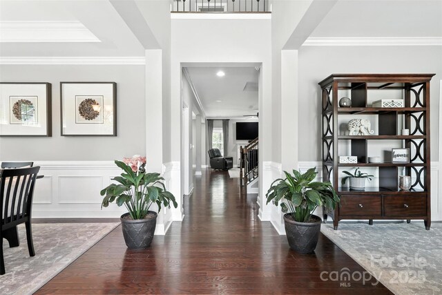2377 Maple Grove Ln NW, Concord, NC 28027 - foyer featuring wood finished floors, a decorative wall, crown molding, stairway, and a wainscoted wall