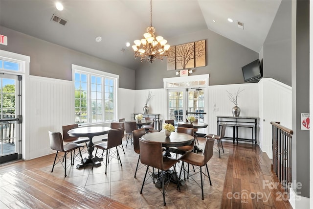 2377 Maple Grove Ln NW, Concord, NC 28027 - dining space with high vaulted ceiling, wood-type flooring, a chandelier, a wainscoted wall, and healthy amount of natural light