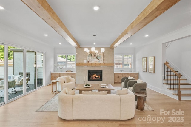 4349 Castleton Rd, Charlotte, NC 28211 - living room with beam ceiling, light wood finished floors, a warm lit fireplace, stairs, and crown molding