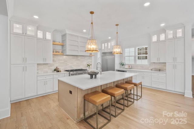 4349 Castleton Rd, Charlotte, NC 28211 - kitchen featuring decorative backsplash, light countertops, recessed lighting, an island with sink, and light wood finished floors