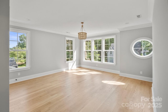 4349 Castleton Rd, Charlotte, NC 28211 - spare room featuring a chandelier, plenty of natural light, ornamental molding, and light wood-style flooring