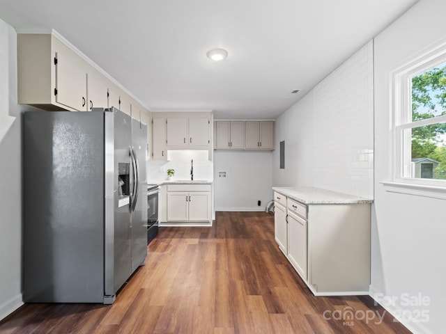 405 Jones St, Monroe, NC 28110 - kitchen featuring appliances with stainless steel finishes, dark wood-type flooring, decorative backsplash, and white cabinetry