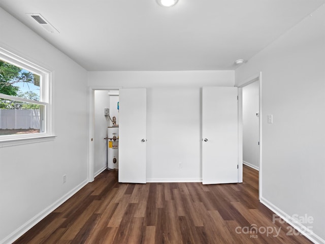 405 Jones St, Monroe, NC 28110 - unfurnished bedroom with wood finished floors and water heater