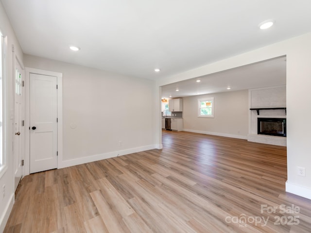 1606 N Rhyne St, Gastonia, NC 28054 - unfurnished living room featuring light wood-style flooring, recessed lighting, and a brick fireplace