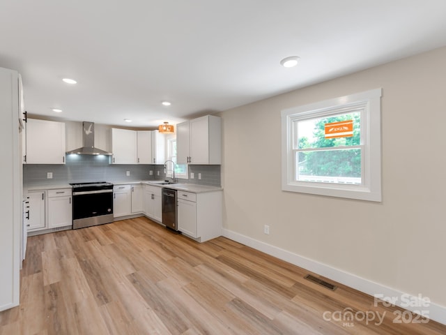 1606 N Rhyne St, Gastonia, NC 28054 - kitchen with stainless steel appliances, wall chimney range hood, light countertops, backsplash, and white cabinetry