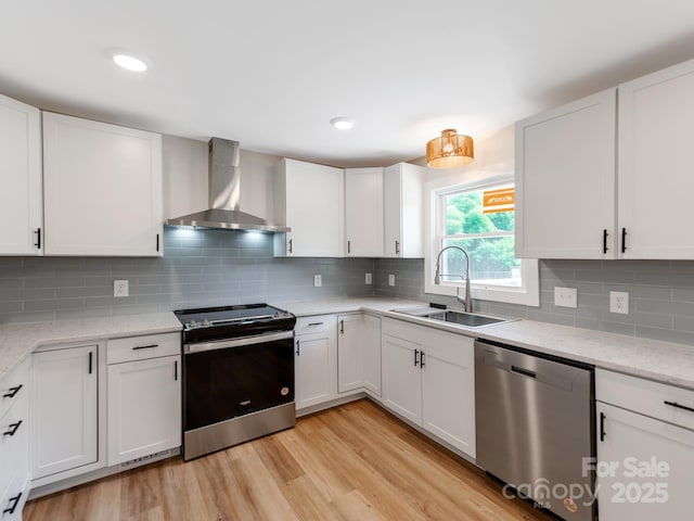 1606 N Rhyne St, Gastonia, NC 28054 - kitchen featuring stainless steel appliances, wall chimney range hood, white cabinetry, light wood-style floors, and recessed lighting