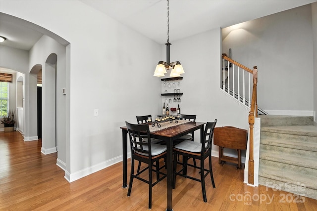 10818 Alvarado Way, Charlotte, NC 28277 - dining room with arched walkways, wood finished floors, stairs, and a chandelier