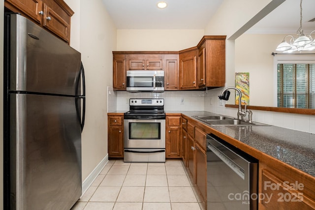 2773 Clover Rd NW, Concord, NC 28027 - kitchen with appliances with stainless steel finishes, a chandelier, brown cabinetry, decorative backsplash, and light tile patterned floors