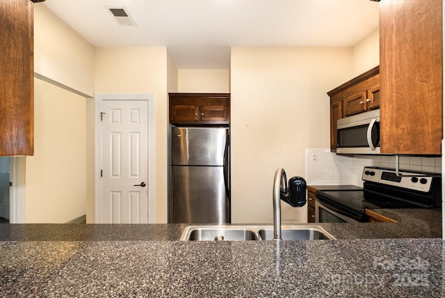 2773 Clover Rd NW, Concord, NC 28027 - kitchen featuring stainless steel appliances, decorative backsplash, and dark brown cabinets