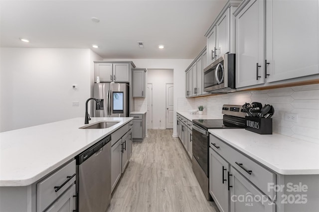 5010 Arbordale Way, Mount Holly, NC 28120 - kitchen with appliances with stainless steel finishes, gray cabinets, light wood-style flooring, backsplash, and light countertops