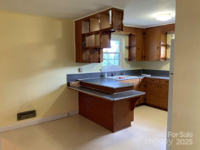 3009 Grier St, Newton, NC 28658 - kitchen featuring open shelves, a peninsula, brown cabinetry, and light flooring