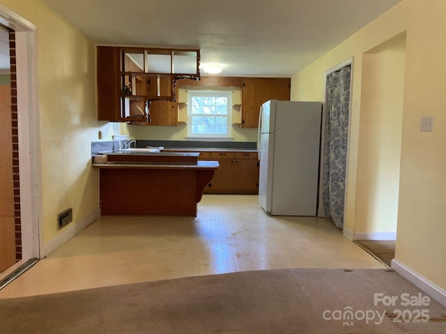 3009 Grier St, Newton, NC 28658 - kitchen featuring freestanding refrigerator, light floors, a peninsula, and open shelves