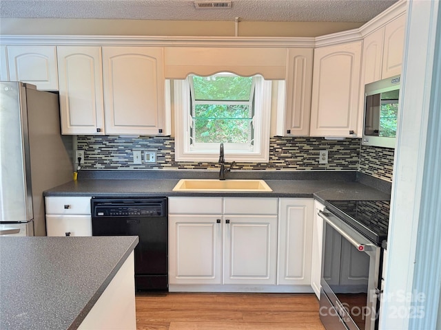 123 Avondale Ridge Rd, Asheville, NC 28803 - kitchen with appliances with stainless steel finishes, dark countertops, white cabinets, and backsplash