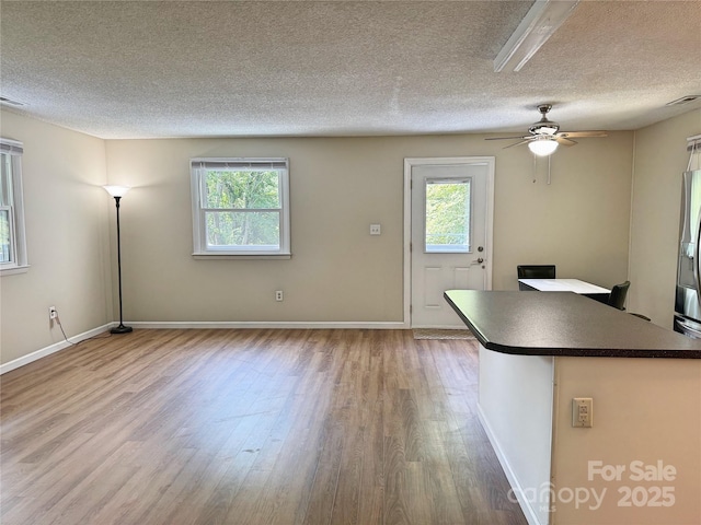 123 Avondale Ridge Rd, Asheville, NC 28803 - kitchen with dark countertops, wood finished floors, a textured ceiling, ceiling fan, and stainless steel fridge