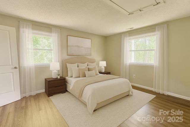 123 Avondale Ridge Rd, Asheville, NC 28803 - bedroom with multiple windows, attic access, a textured ceiling, and wood finished floors