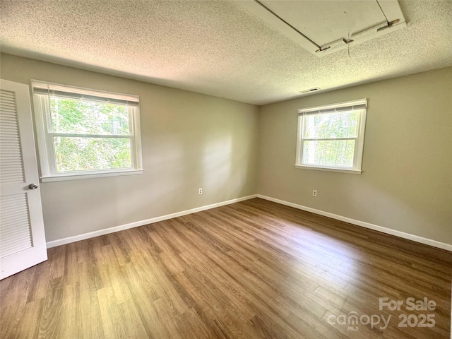 123 Avondale Ridge Rd, Asheville, NC 28803 - empty room featuring plenty of natural light, a textured ceiling, and wood finished floors
