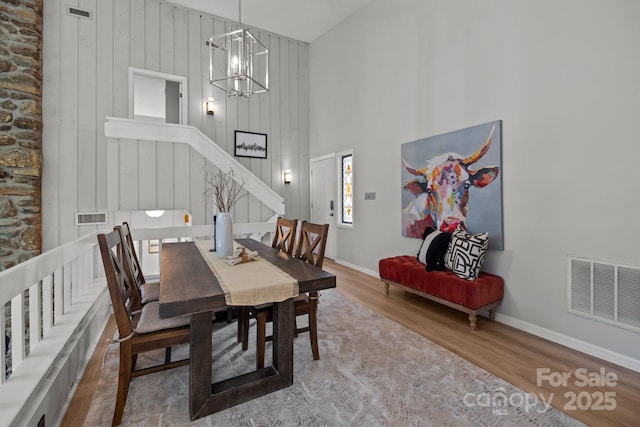 4208 Burning Tree Dr, Charlotte, NC 28277 - dining room with wood finished floors, stairs, a chandelier, and a high ceiling