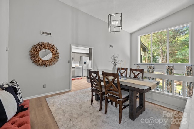 4208 Burning Tree Dr, Charlotte, NC 28277 - dining room with plenty of natural light, light wood-type flooring, a chandelier, and high vaulted ceiling