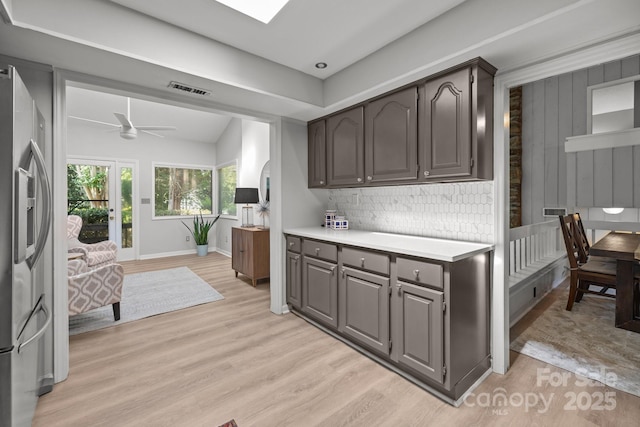 4208 Burning Tree Dr, Charlotte, NC 28277 - kitchen with stainless steel refrigerator with ice dispenser, light wood-style floors, light countertops, ceiling fan, and decorative backsplash