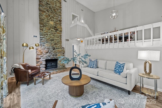 4208 Burning Tree Dr, Charlotte, NC 28277 - living room with wood finished floors, a towering ceiling, a fireplace, and a chandelier