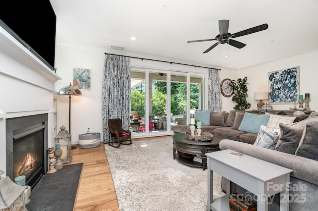 3899 Zemosa Ln NW, Concord, NC 28027 - living area featuring a ceiling fan, a fireplace with flush hearth, light wood finished floors, crown molding, and recessed lighting