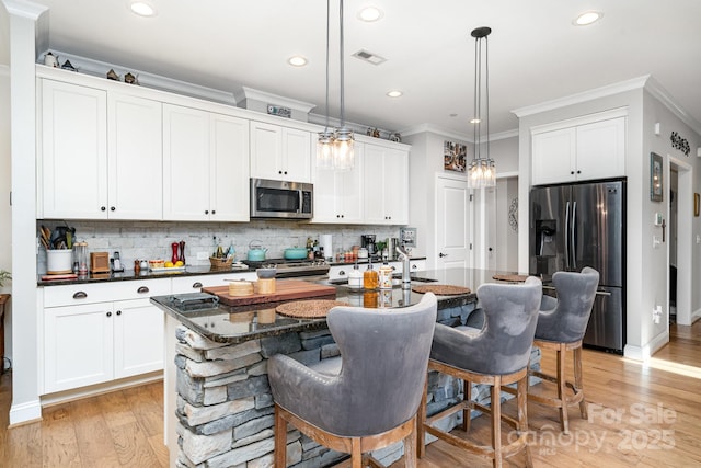 3899 Zemosa Ln NW, Concord, NC 28027 - kitchen featuring stainless steel appliances, backsplash, ornamental molding, hanging light fixtures, and a kitchen island with sink