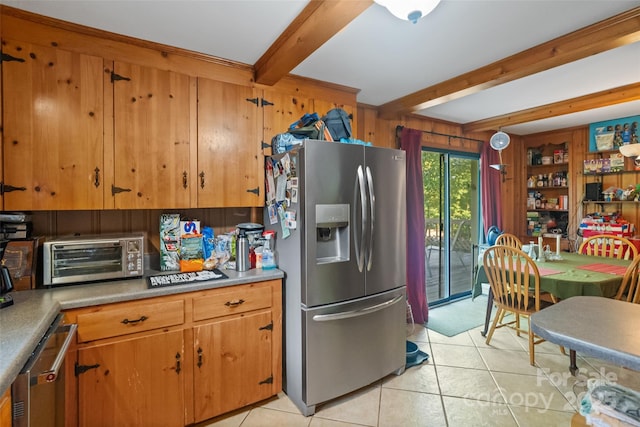 6632 Candlewood Dr, Charlotte, NC 28210 - kitchen with stainless steel appliances, beamed ceiling, light tile patterned floors, brown cabinetry, and light countertops