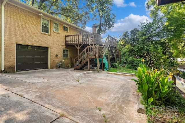 6632 Candlewood Dr, Charlotte, NC 28210 - view of property exterior featuring a wooden deck, stairs, brick siding, a garage, and a chimney