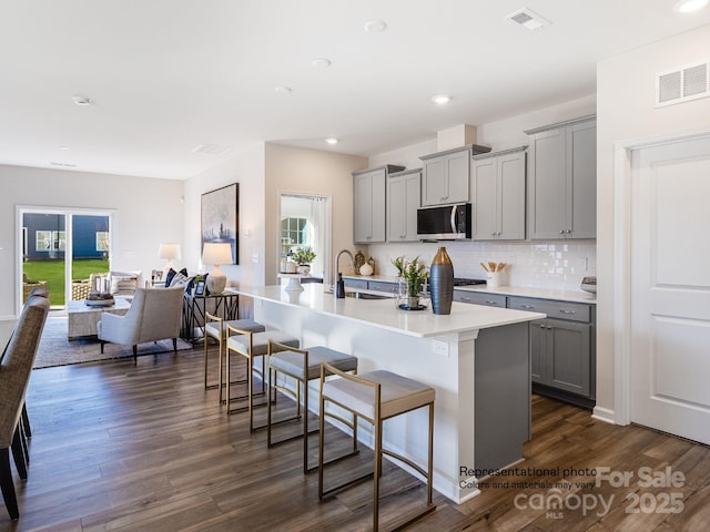 1016 Lookout Shoals Dr, Fort Mill, SC 29715 - kitchen with gray cabinets, stainless steel microwave, a kitchen bar, healthy amount of natural light, and recessed lighting