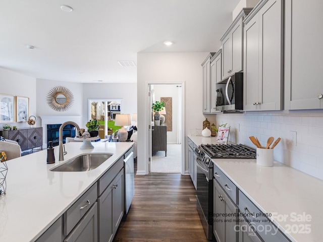 1016 Lookout Shoals Dr, Fort Mill, SC 29715 - kitchen featuring stainless steel appliances, open floor plan, gray cabinets, dark wood-style flooring, and light countertops