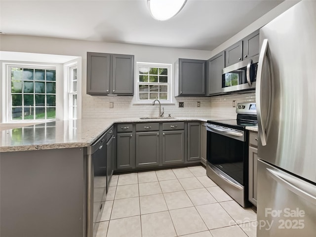 8701 Holly Creek Ct, Charlotte, NC 28216 - kitchen featuring appliances with stainless steel finishes, gray cabinetry, light tile patterned flooring, and tasteful backsplash