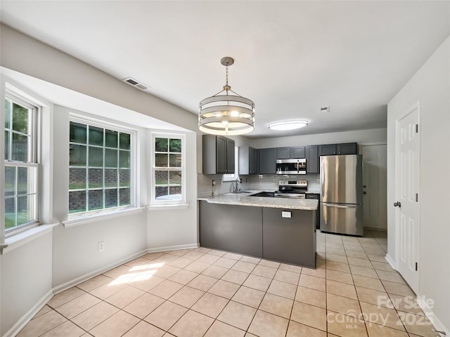 8701 Holly Creek Ct, Charlotte, NC 28216 - kitchen with stainless steel appliances, plenty of natural light, light tile patterned flooring, and a peninsula
