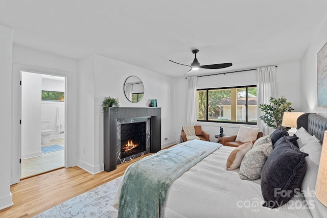 4209 Windwood Cir, Charlotte, NC 28226 - bedroom with a premium fireplace, wood finished floors, connected bathroom, and ceiling fan