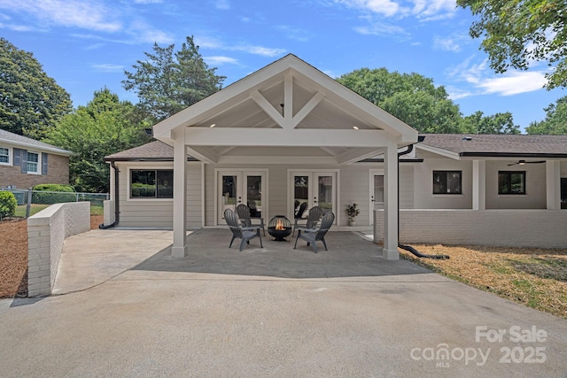4209 Windwood Cir, Charlotte, NC 28226 - rear view of property featuring french doors, a fire pit, a patio, brick siding, and roof with shingles