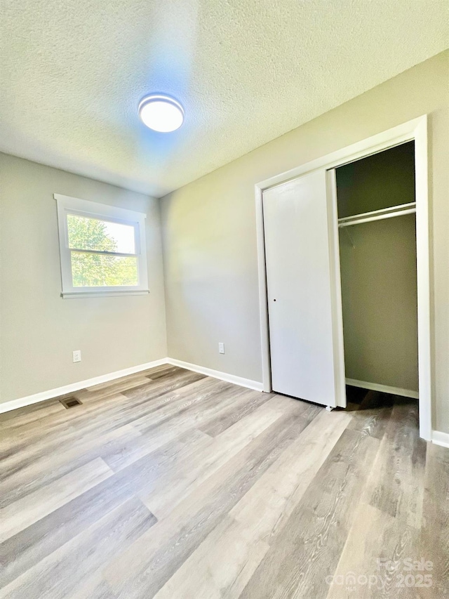 1678 Nelson Dr, Newton, NC 28658 - unfurnished bedroom featuring wood finished floors, a textured ceiling, and a closet