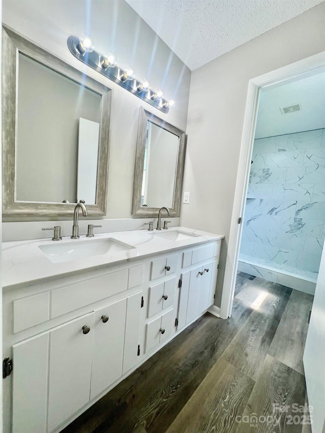 1678 Nelson Dr, Newton, NC 28658 - full bathroom with wood finished floors, double vanity, and a textured ceiling