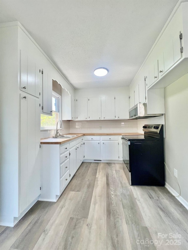 1678 Nelson Dr, Newton, NC 28658 - kitchen with range with electric stovetop, light wood-style flooring, white cabinets, decorative backsplash, and a textured ceiling