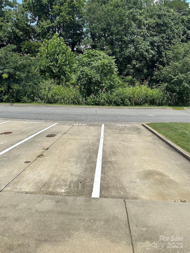 215 Linkside Ct SE, Lenoir, NC 28645 - uncovered parking lot with view of scattered trees