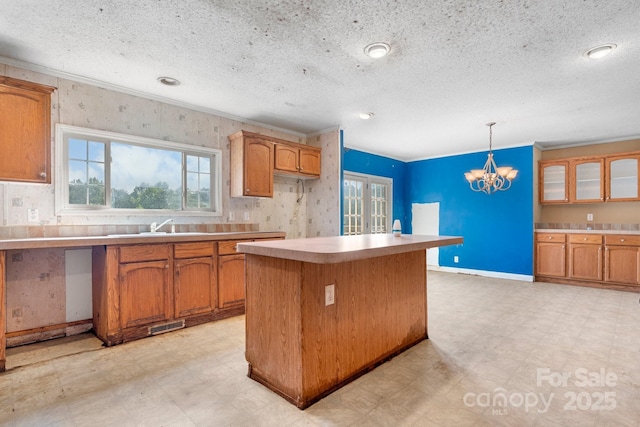 6314 Providence Church Rd, Vale, NC 28168 - kitchen featuring light flooring, brown cabinets, a chandelier, a textured ceiling, and light countertops