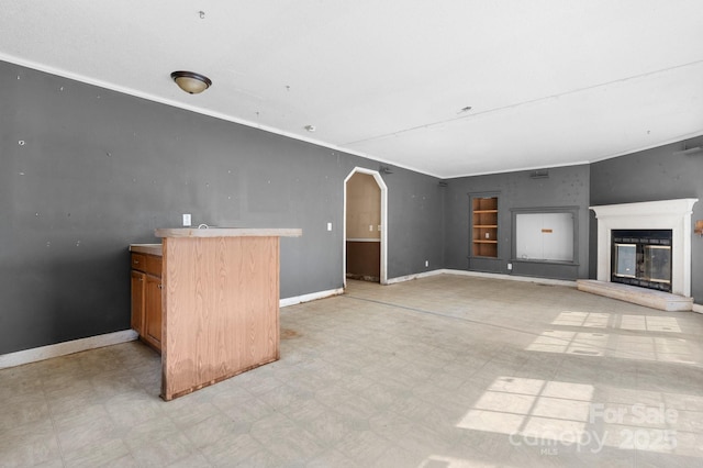 6314 Providence Church Rd, Vale, NC 28168 - unfurnished living room with light flooring, a glass covered fireplace, arched walkways, and ornamental molding