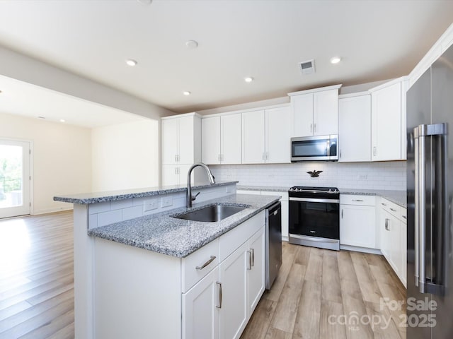1206 Pebble Grove Dr, Clover, SC 29710 - kitchen with appliances with stainless steel finishes, a kitchen island with sink, light wood finished floors, tasteful backsplash, and recessed lighting