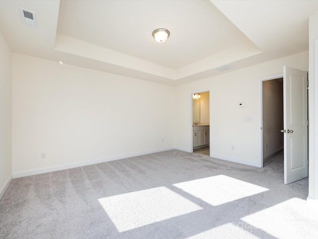 1206 Pebble Grove Dr, Clover, SC 29710 - unfurnished bedroom featuring a tray ceiling, light carpet, and connected bathroom