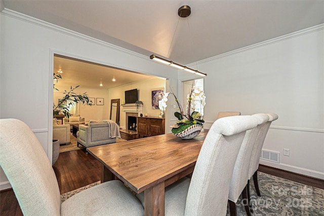 5301 Addison Dr, Charlotte, NC 28211 - dining space with ornamental molding, dark wood finished floors, and a fireplace