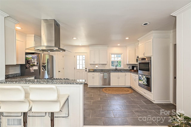 5301 Addison Dr, Charlotte, NC 28211 - kitchen with stainless steel appliances, island exhaust hood, tasteful backsplash, a peninsula, and recessed lighting