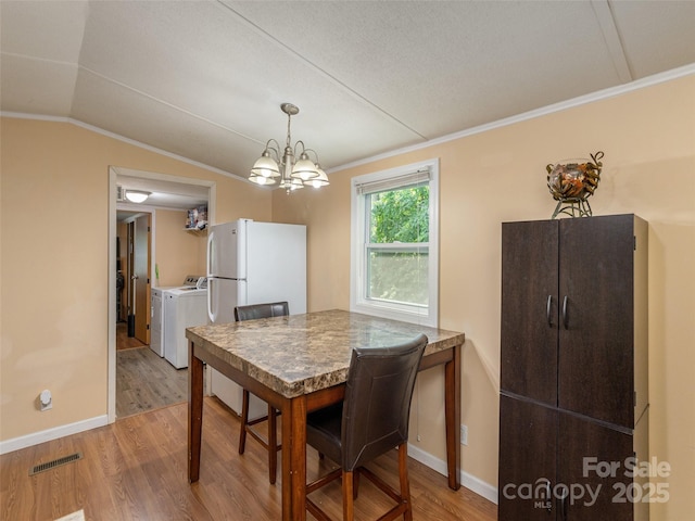 5 Shenandoah Rd, Asheville, NC 28805 - dining space featuring separate washer and dryer, light wood-type flooring, vaulted ceiling, a chandelier, and ornamental molding