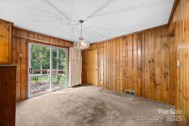 331 Elwood St, Kannapolis, NC 28081 - carpeted empty room with wooden walls, a textured ceiling, and a chandelier