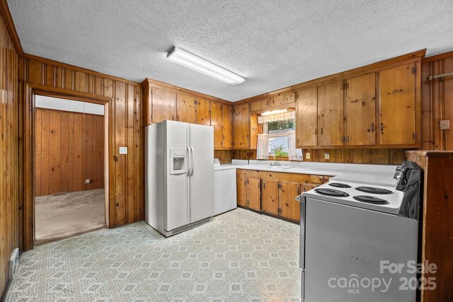 331 Elwood St, Kannapolis, NC 28081 - kitchen featuring white appliances, washer / clothes dryer, wooden walls, brown cabinets, and light countertops